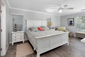 a bedroom with a bed and a dresser and a window at Sweetpeas Cottage in Jekyll Island +17 photos