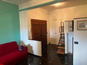 a living room with a red couch and a wooden door at Angelo Home in Genova