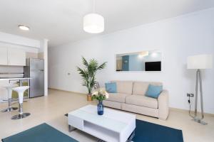 ein Wohnzimmer mit Sofa und Tisch in der Unterkunft Brisa - Armonía Park, Bajamar in El Puertito