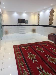Habitación grande con alfombra roja en el suelo en إستراحة الريف, en Kalbā