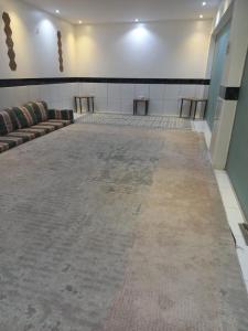 Una habitación vacía con sofás y mesas en una habitación. en إستراحة الريف, en Kalbā