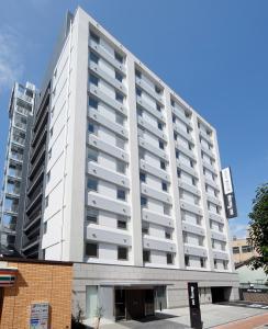 a large white building with balconies on it at Dormy Inn Nagano in Nagano