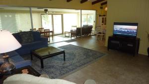 een woonkamer met een blauwe bank en een tv bij Cottage By The Sea - Unit A in Jekyll Island