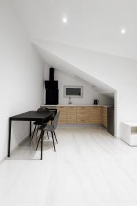 ein schwarzer Tisch und Stuhl in einem weißen Raum in der Unterkunft DeLuxe Studio Lumineux, Rénové, Parking Gratuit, MULHOUSE CENTRE in Mulhouse