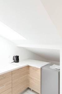 eine Küche mit weißen Arbeitsplatten und einem Kühlschrank in der Unterkunft DeLuxe Studio Lumineux, Rénové, Parking Gratuit, MULHOUSE CENTRE in Mulhouse