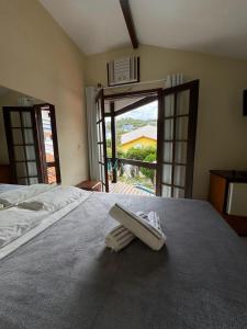 une chambre avec un lit avec une serviette dessus dans l'établissement Pousada Kaianoá, à Arraial do Cabo 86 autres photos