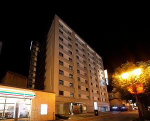a tall building at night with a street light at Dormy Inn Nagano in Nagano