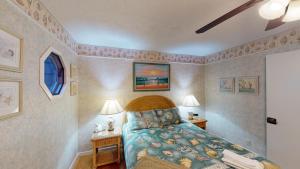 a bedroom with a bed and two tables with lamps at Ocean Retreat in Jekyll Island