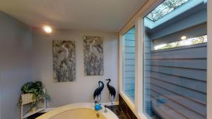 two birds on the wall of a bathroom with a tub at Ocean Retreat in Jekyll Island +16 photos