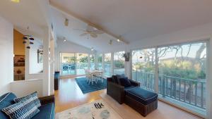 a living room with a ceiling fan and a balcony at Ocean Retreat in Jekyll Island