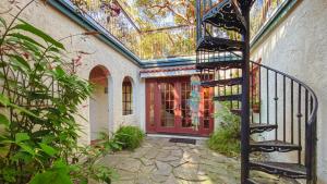 ein Haus mit einer Wendeltreppe vor einer roten Tür in der Unterkunft Hacienda in Jekyll Island
