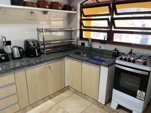 a kitchen with a sink and a stove at Chácara piscina aquecida in Juazeiro do Norte