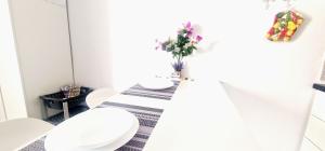 a bathroom with a table with a toilet and a vase of flowers at MARINE HOME in Costa Del Silencio +12 photos