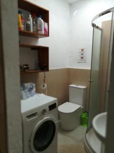 a bathroom with a toilet and a washing machine at Bett 1 im Frauen 2-Bettzimmer Nur Frauen Only women Solo mucheres in Mogán