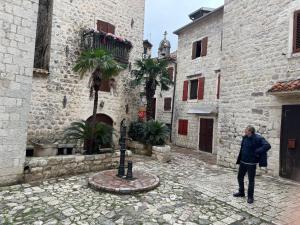 Un homme debout dans une ruelle d'un vieux bâtiment dans l'établissement Last Summer hotel Kotor, à Kotor