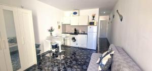 eine weiße Küche mit einem Waschbecken und einer Waschmaschine in der Unterkunft MARINE HOME in Costa Del Silencio