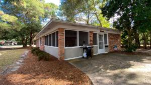 a small brick house with a driveway in front of it at Island Pines in Jekyll Island