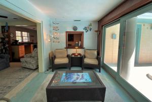 een woonkamer met een tafel en stoelen en een woonkamer bij Kisses Cottage in Jekyll Island