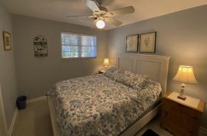 een slaapkamer met een bed en een plafondventilator bij Kisses Cottage in Jekyll Island +16 foto's