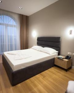 a bedroom with a large bed with a black headboard at Leo Hotel in Kukës +133 photos