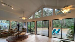 a dining room with a table and chairs and windows at Hollybourne II in Jekyll Island