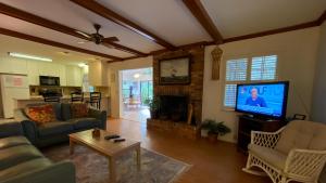 a living room with a couch and a tv at Hollybourne II in Jekyll Island