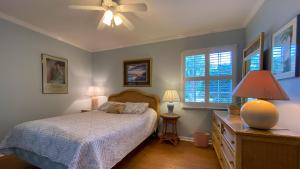 a bedroom with a bed and a ceiling fan at Hollybourne II in Jekyll Island