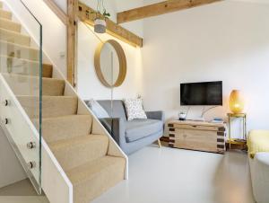 Una sala de estar con una escalera y un espejo. en The Nest at Severels, en North Mundham
