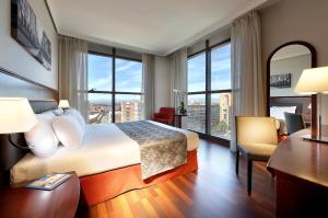 a hotel room with a bed, chair and a window at Crisol Vía Castellana in Madrid