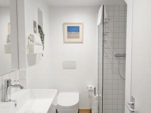 Un baño blanco con inodoro y lavabo. en The Nest at Severels, en North Mundham 27 fotos más