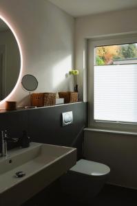 a bathroom with a sink and a toilet and a mirror at Ferienwohnung Grüne Boje in Bullay +47 photos