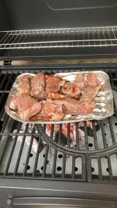 une poêle de viande qui cuit sur un four dans l'établissement Tekrour- la case des hotes - Chambre individuelle avec piscine et terrasse, à Mbour