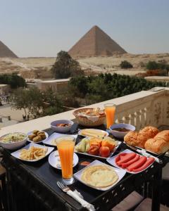 un vassoio di cibo su un tavolo di fronte alle piramidi di Soul Scarab Pyramids View a Il Cairo
