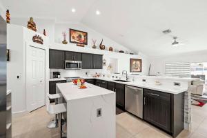 eine Küche mit schwarzen Schränken und einer weißen Arbeitsplatte in der Unterkunft Endless Summer - 4 Bedroom with Gym and Jacuzzi in Matlacha