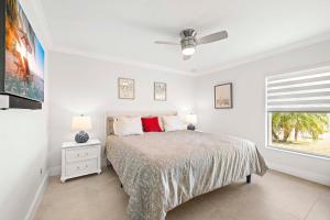 ein weißes Schlafzimmer mit einem Bett und einem Fenster in der Unterkunft Endless Summer - 4 Bedroom with Gym and Jacuzzi in Matlacha + 29 Fotos