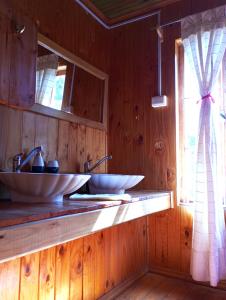 two sinks in a wooden bathroom with a window at Palmera el Refugio in Olmué