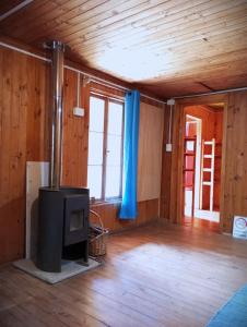 a living room with a stove in a room with wooden walls at Palmera el Refugio in Olmué