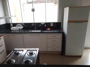 a kitchen with a stove and a white refrigerator at Casa de Carolinda in Uberaba