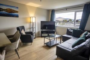 a living room with a couch and a flat screen tv at Skiddaw Heights in Keswick