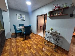 ein Esszimmer mit einem Tisch und blauen Stühlen und einem Tisch und einem Tischaufsteller in der Unterkunft Casa acogedora y tranquila para descansar in Chimbote