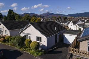 a white house with a black roof in a town at Skiddaw Heights in Keswick