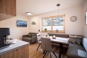 eine Küche und ein Wohnzimmer mit einem Tisch und einer Couch in der Unterkunft Apart Elfi in Aschau