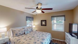 a bedroom with a bed and a ceiling fan at Americana Beach in Jekyll Island