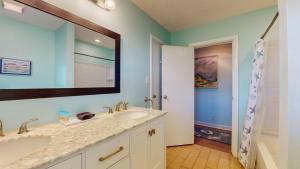 a bathroom with two sinks and a large mirror at Americana Beach in Jekyll Island +27 photos