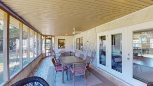 a screened in porch with a table and chairs at Americana Beach in Jekyll Island