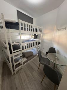 a room with a white bunk bed and a glass table at Trio Den in Zone 2 - Willesden Green in London +10 photos