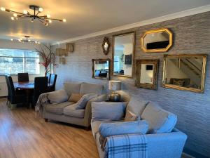 a living room with a couch and a table and mirrors at The Maisonette - Central Windermere, with parking in Windermere