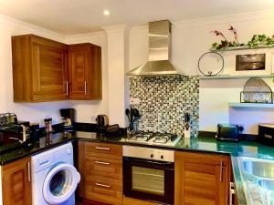 a kitchen with a stove and a dishwasher in it at The Maisonette - Central Windermere, with parking in Windermere +20 photos