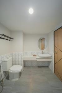 un baño con inodoro y lavabo en Mintara Hotel - โรงแรมมินธารา มีนบุรี, en Min Buri