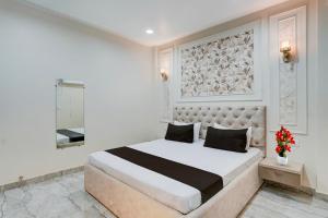 a white bedroom with a large bed and a mirror at Townhouse DSIDC Bawana Formerly Kanhaiya Residency in Bawāna